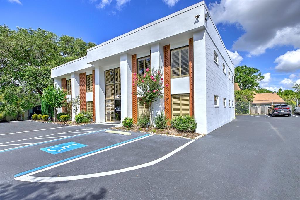 A two-story white commercial building with brown shutters and a paved parking lot — 4927 SOUTHFORK DRIVE, LAKELAND, FL