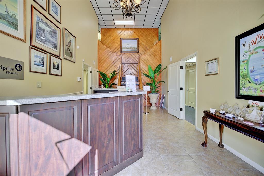 A reception area features a dark wood desk, tile flooring, and wood-paneled accent wall — 4927 SOUTHFORK DRIVE, LAKELAND, FL