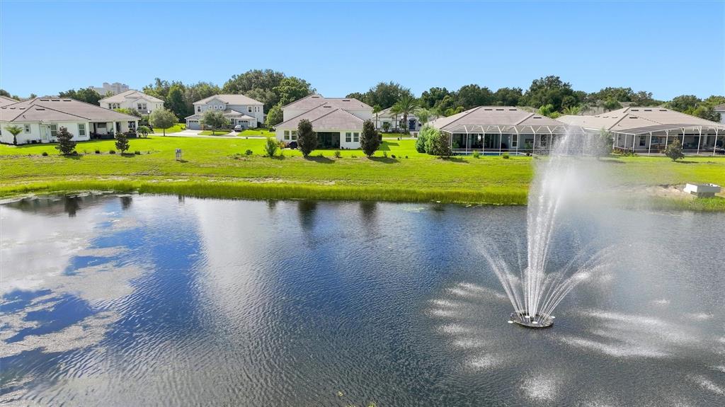 An aerial view of a pond with a fountain in front of several suburban houses — 1458 OLYMPIC CLUB BOULEVARD, DAVENPORT, FL