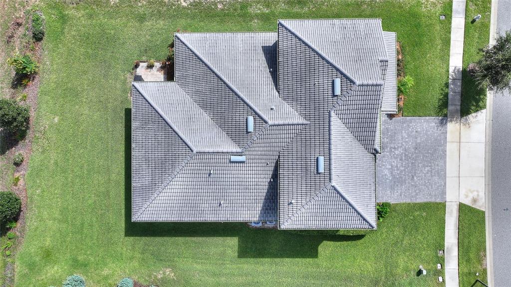 An aerial view shows a house with a gray tiled roof and a paved driveway — 1458 OLYMPIC CLUB BOULEVARD, DAVENPORT, FL