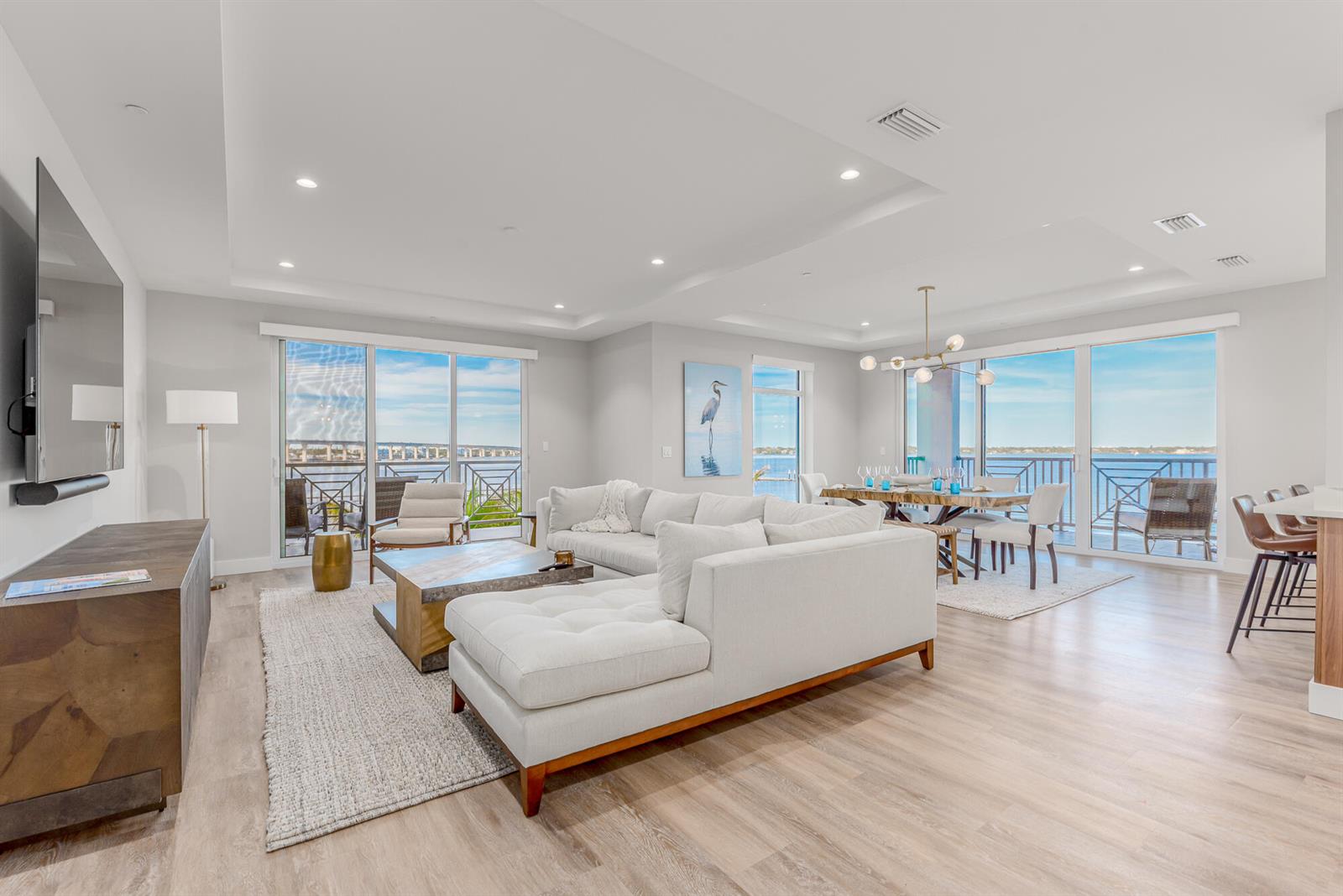 A bright, open-concept living and dining area features light wood floors and floor-to-ceiling windows — 41 SW Seminole Street # 306, Stuart FL 34994, STUART, FL