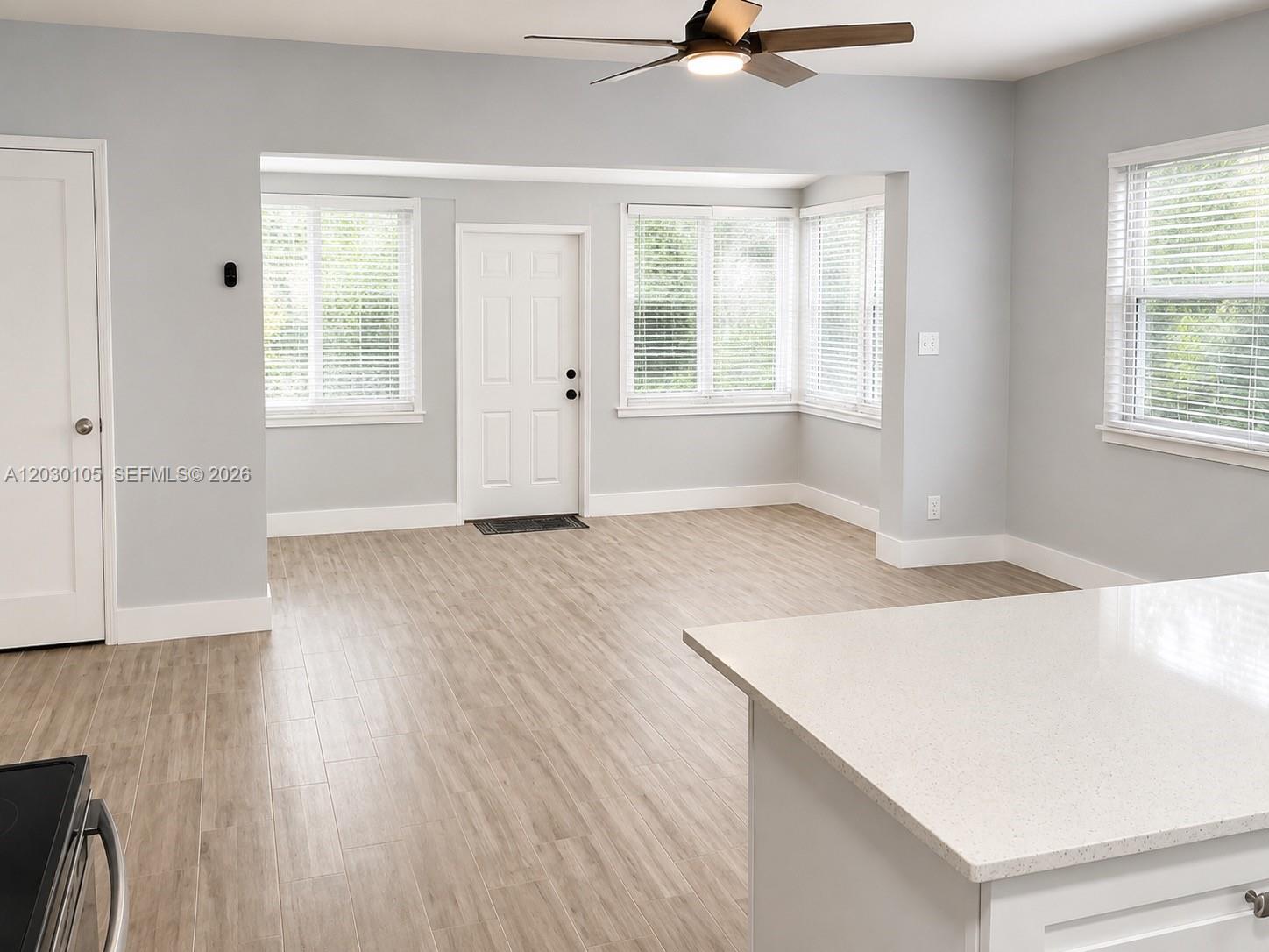 An interior view shows a room with light gray walls, wood-look flooring, and a ceiling fan — 209 SW 5th St # 209, Dania Beach FL 33004, DANIA BEACH, FL