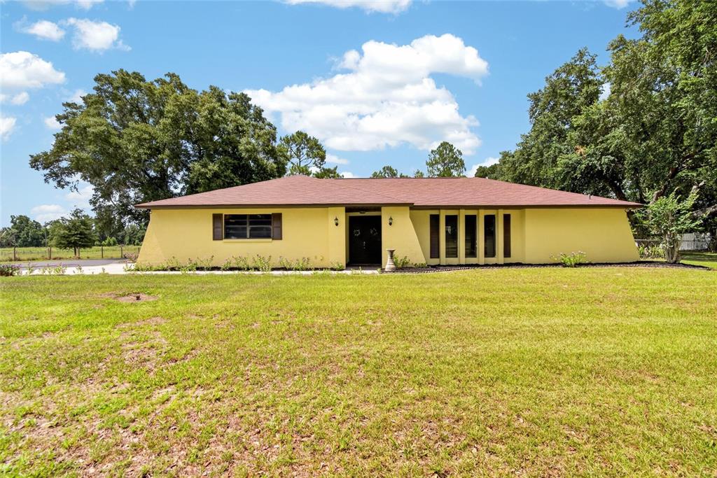 A yellow, single-story house with a brown roof sits on a large, grassy lot — 3708 JOE SANCHEZ RD, PLANT CITY, FL