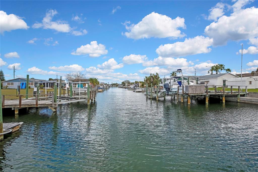 A canal view showing wooden boat docks on both sides and several docked boats — 6601 SEA RANCH DRIVE, HUDSON, FL