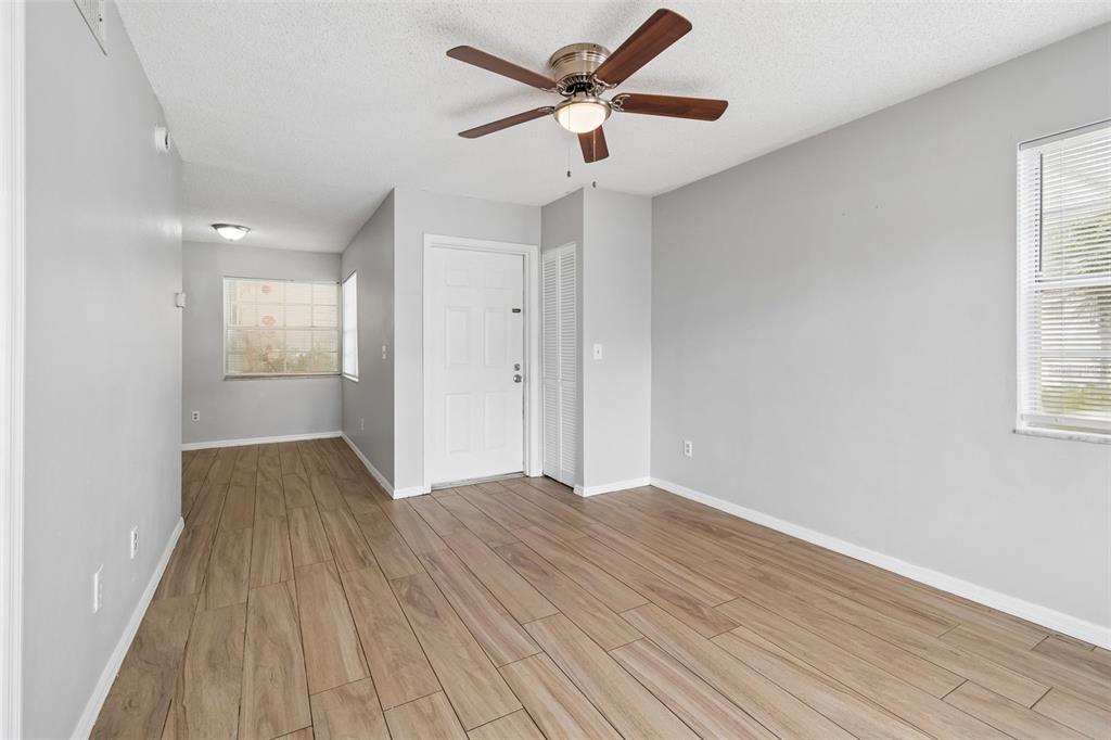 An empty room features light gray walls, wood-look tile flooring, and a ceiling fan — 6915 STONES THROW CIRCLE N UNIT 3106, ST PETERSBURG, FL