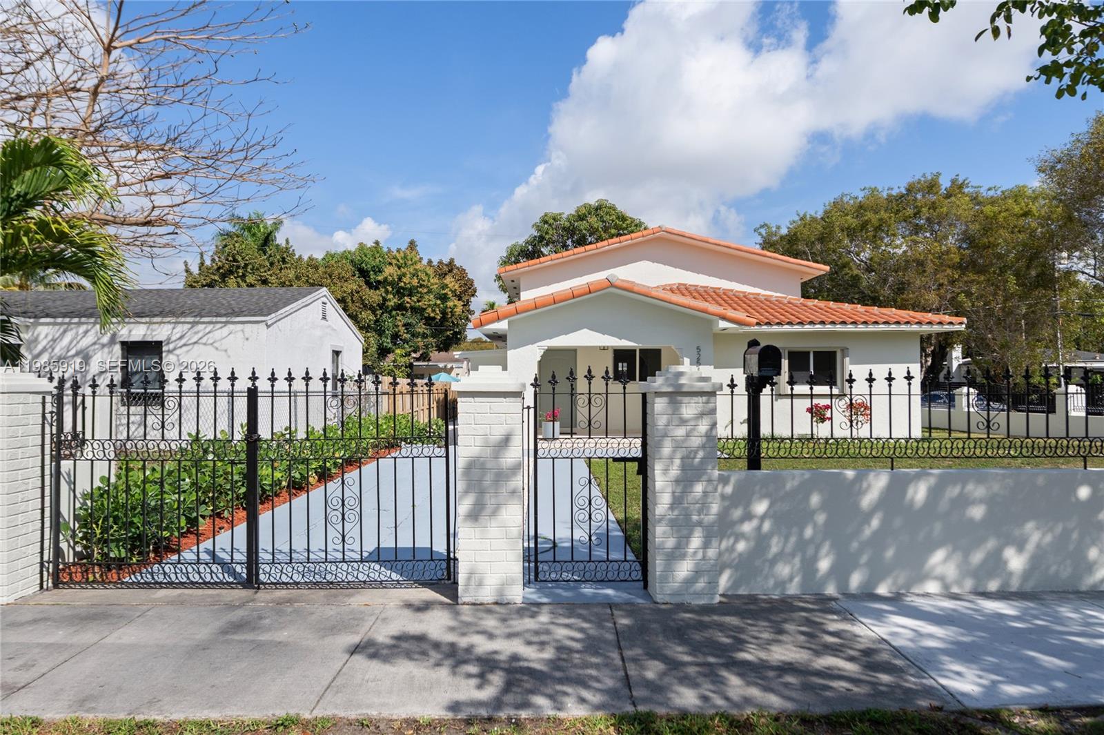 A white house with a red tile roof sits behind a black metal fence — 5251 SW 6th St, Miami FL 33134, MIAMI, FL