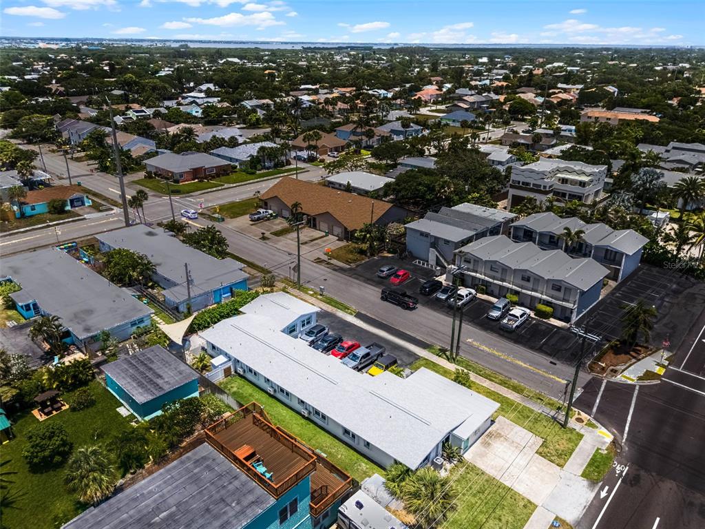 An aerial view shows a multi-unit residential complex with parking lots and surrounding neighborhood streets — 402 S ORLANDO AVENUE, COCOA BEACH, FL