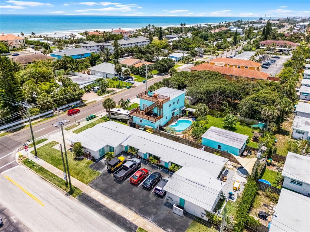 An aerial view shows a multi-unit residential property with a pool and parking lot — 402 S ORLANDO AVENUE, COCOA BEACH, FL