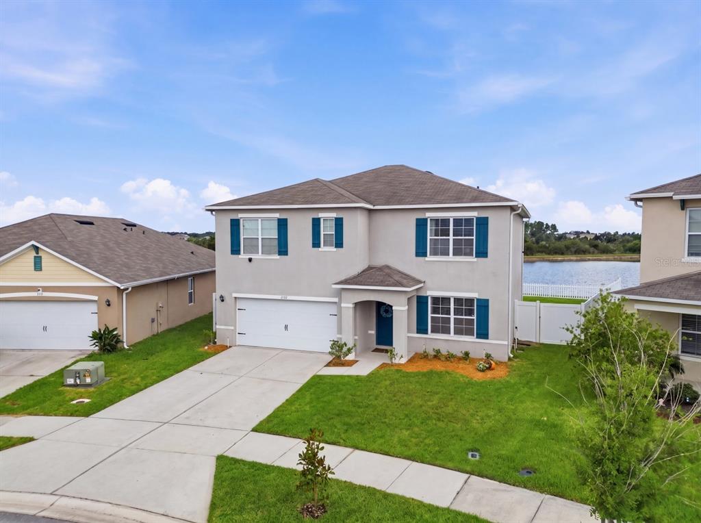 A two-story suburban house with a gray exterior, blue shutters, and a two-car garage — 2767 GRANDBURY GROVE ROAD, LAKELAND, FL