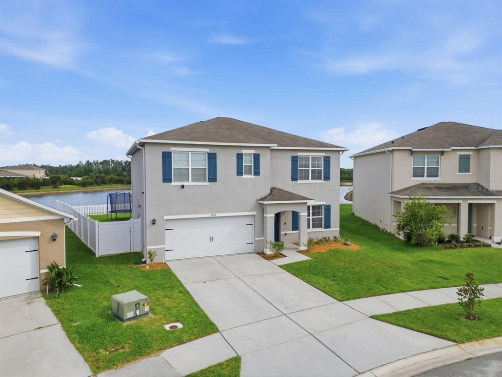 An aerial view of a two-story gray house with a white garage and blue shutters — 2767 GRANDBURY GROVE ROAD, LAKELAND, FL