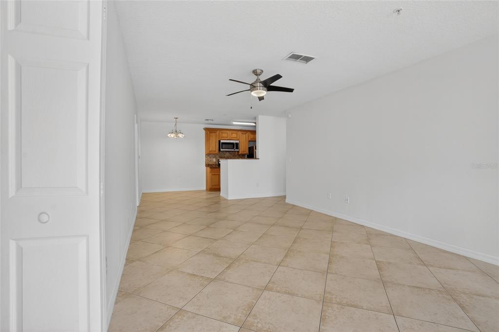 An open-concept living and dining area features light-colored tile flooring and a ceiling fan — 4364 S KIRKMAN ROAD UNIT 307, ORLANDO, FL