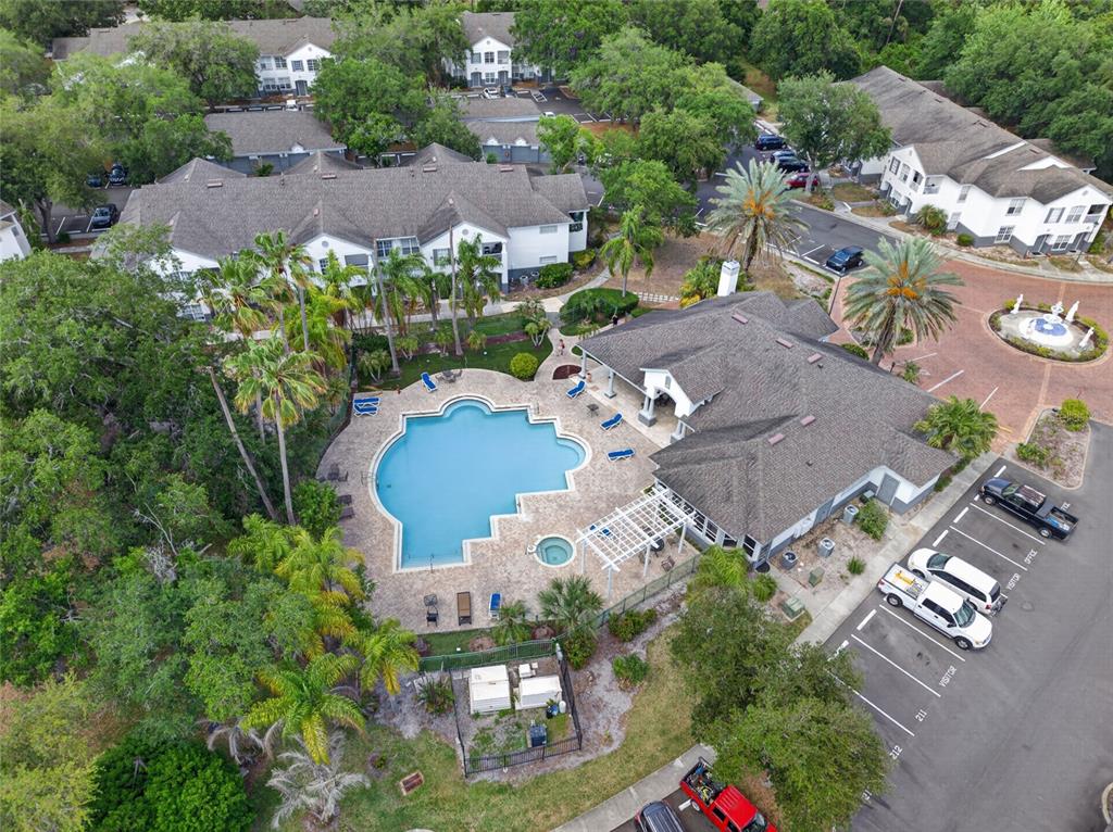 An aerial view shows a swimming pool, clubhouse, and parking lot at an apartment complex — 4364 S KIRKMAN ROAD UNIT 307, ORLANDO, FL