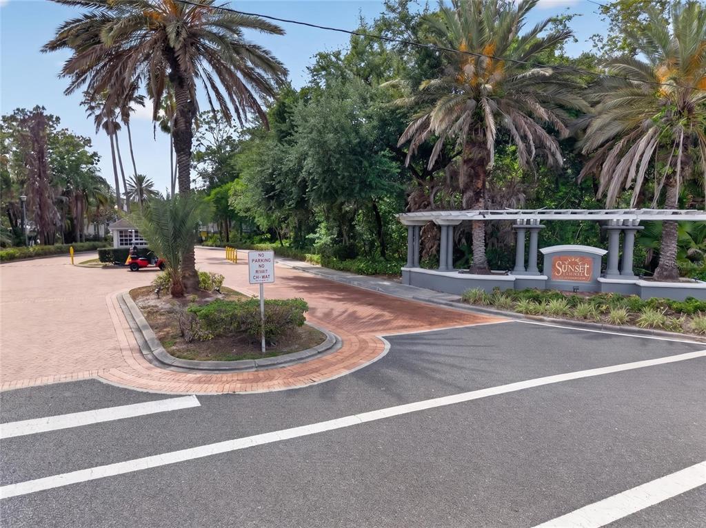 The entrance to the Sunset Palms community features a brick-paved driveway, landscaping, and signage — 4364 S KIRKMAN ROAD UNIT 307, ORLANDO, FL