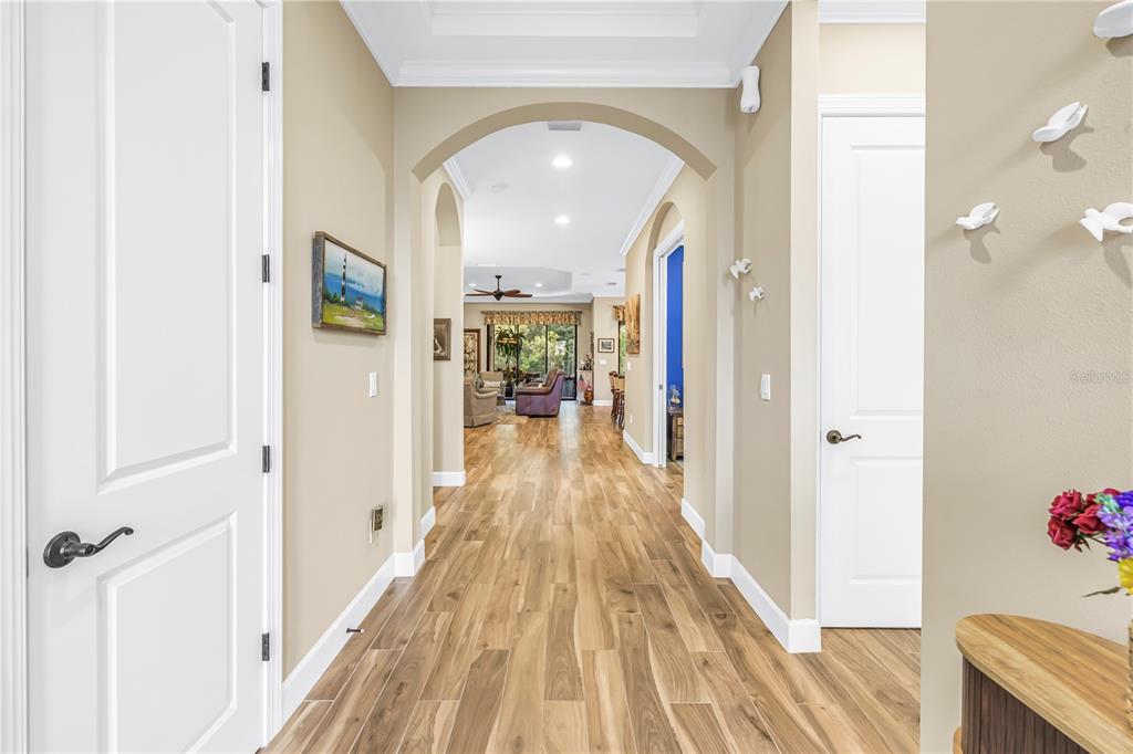 An entryway features a white front door with glass panels, a console table, and nautical decor — 9912 BATCHELDER TERRACE, PALMETTO, FL