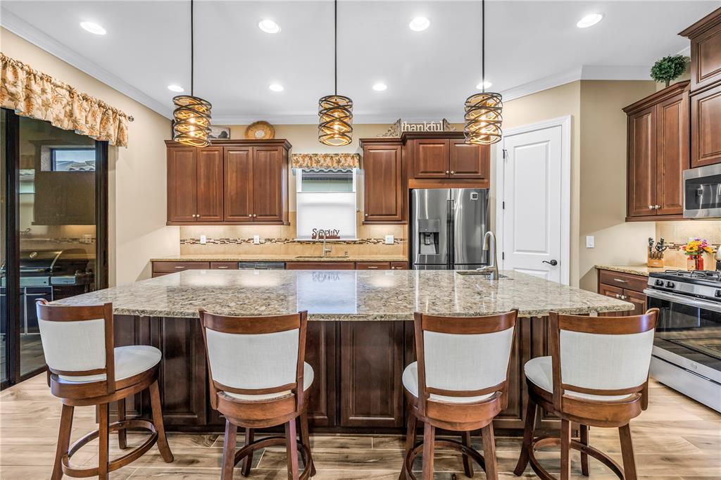 A view down a hallway with wood-look tile flooring leading toward an open living area — 9912 BATCHELDER TERRACE, PALMETTO, FL