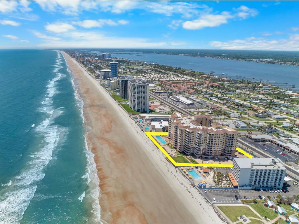 An aerial view of a beachfront resort complex with two pools and surrounding coastal landscape — 2515 S ATLANTIC AVENUE UNIT 301, DAYTONA BEACH, FL