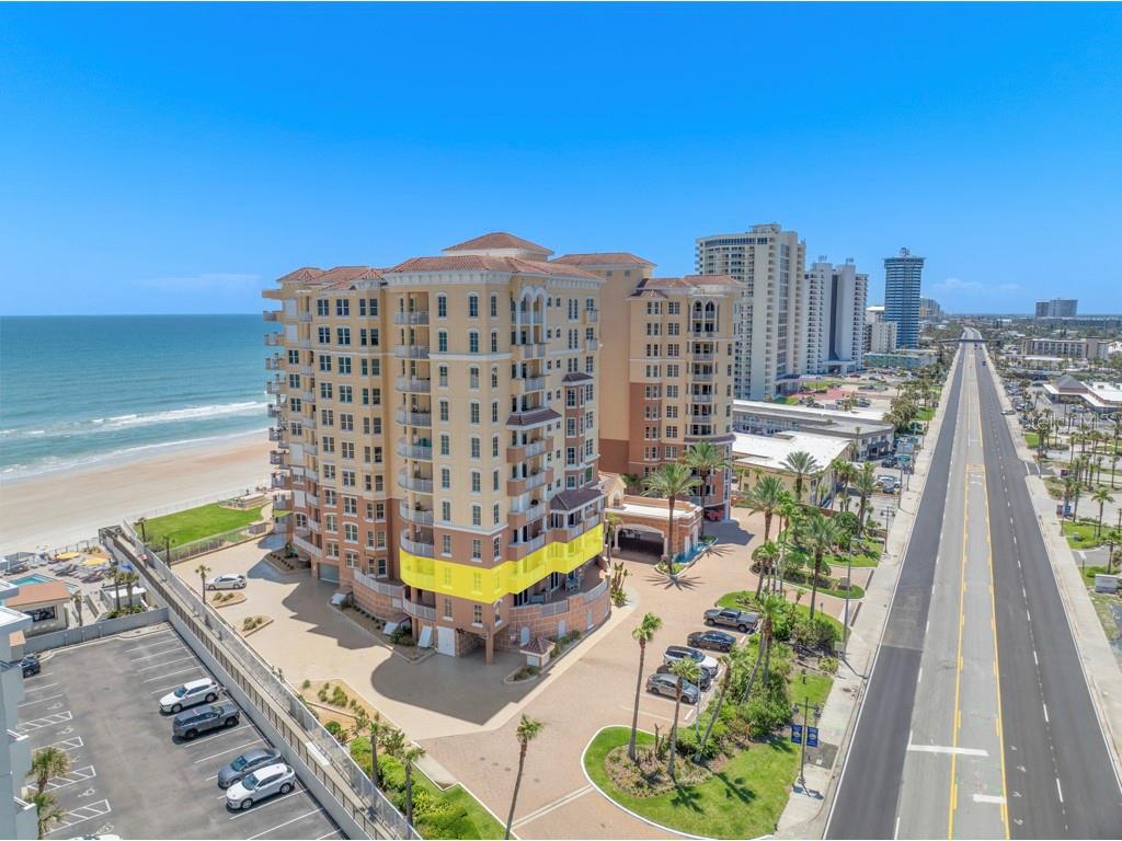 An aerial view of a multi-story beachfront condominium building with a highlighted yellow section — 2515 S ATLANTIC AVENUE UNIT 301, DAYTONA BEACH, FL