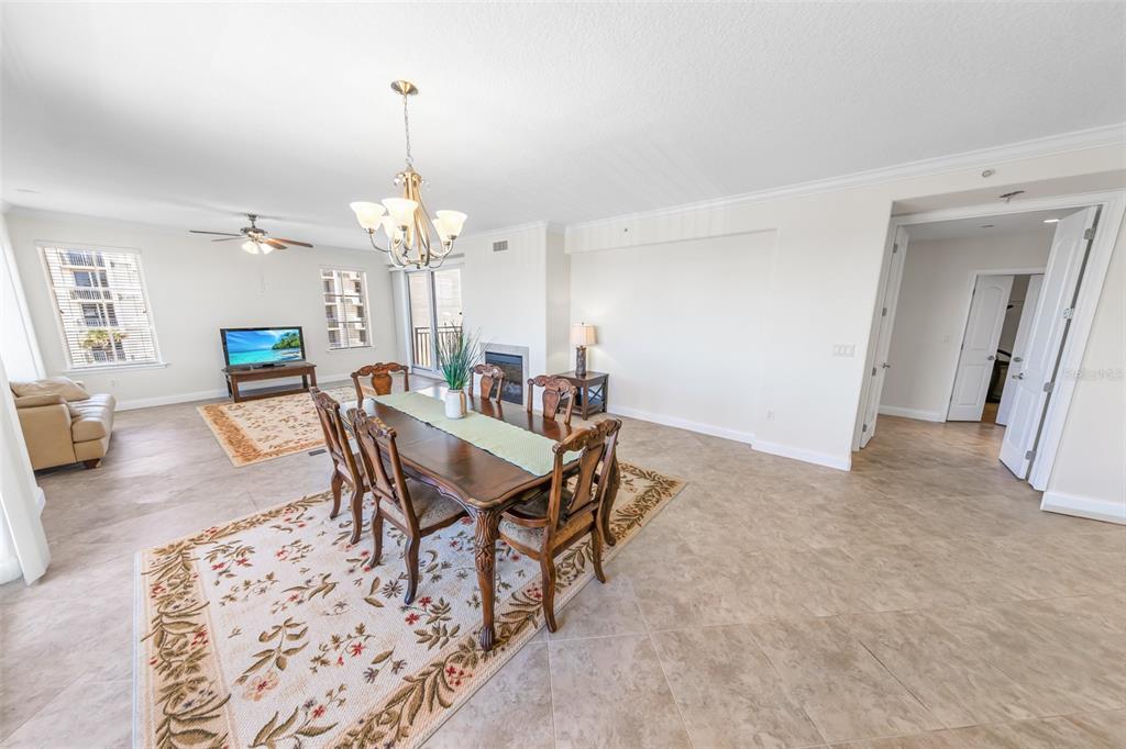 An open-concept dining and living area features tile flooring, a fireplace, and a chandelier — 2515 S ATLANTIC AVENUE UNIT 301, DAYTONA BEACH, FL