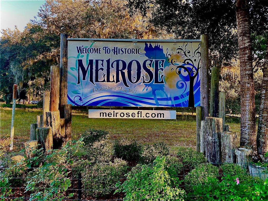 A sign reading Welcome to Historic Melrose stands outdoors among trees and landscaping — 125 SILVER DOLLAR POND ROAD, HAWTHORNE, FL