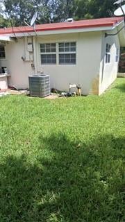 Exterior view of a light-colored house with a red roof and an outdoor AC unit — 5620 Monroe Street, Hollywood FL 33023, HOLLYWOOD, FL