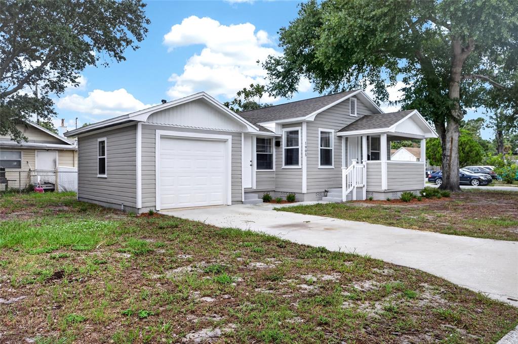 A gray, single-story house with a white garage door, front porch, and concrete driveway — 1905 24TH STREET S, ST PETERSBURG, FL