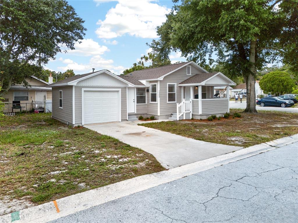 A single-story house with gray siding, a white garage door, and a front porch — 1905 24TH STREET S, ST PETERSBURG, FL