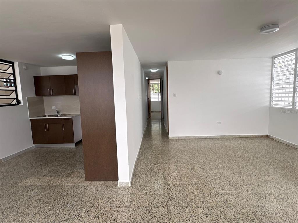An interior view shows a kitchen with dark cabinets adjacent to an open living area — cz8 126A, CAROLINA, PR