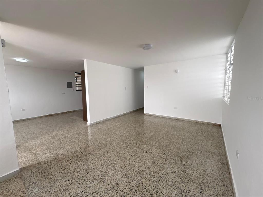 An empty room with white walls, a speckled tile floor, and a large window — cz8 126A, CAROLINA, PR