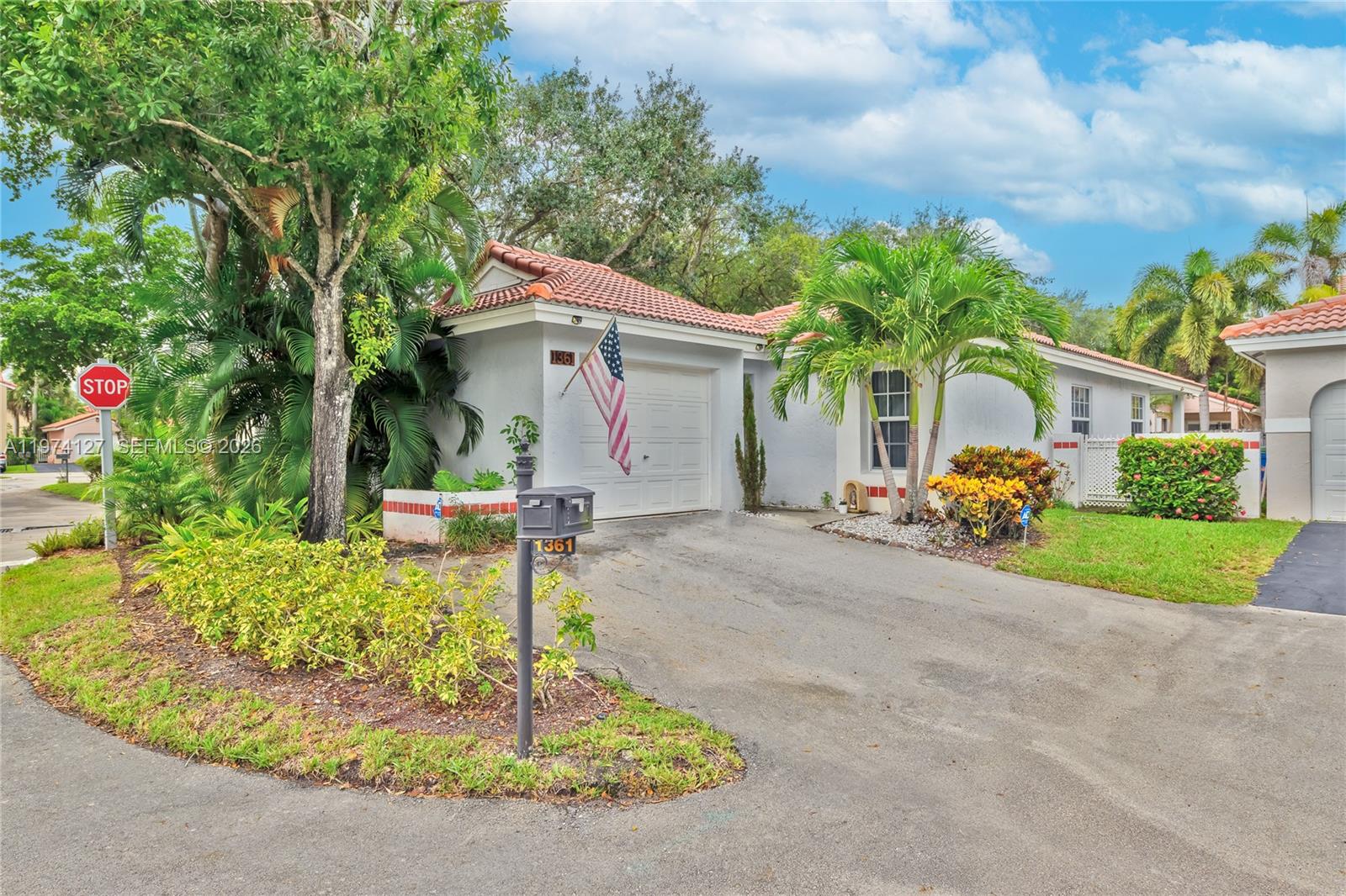 A single-story house with a white stucco exterior, a tile roof, and a paved driveway — 1361 Seagrape Cir, Weston FL 33326, WESTON, FL
