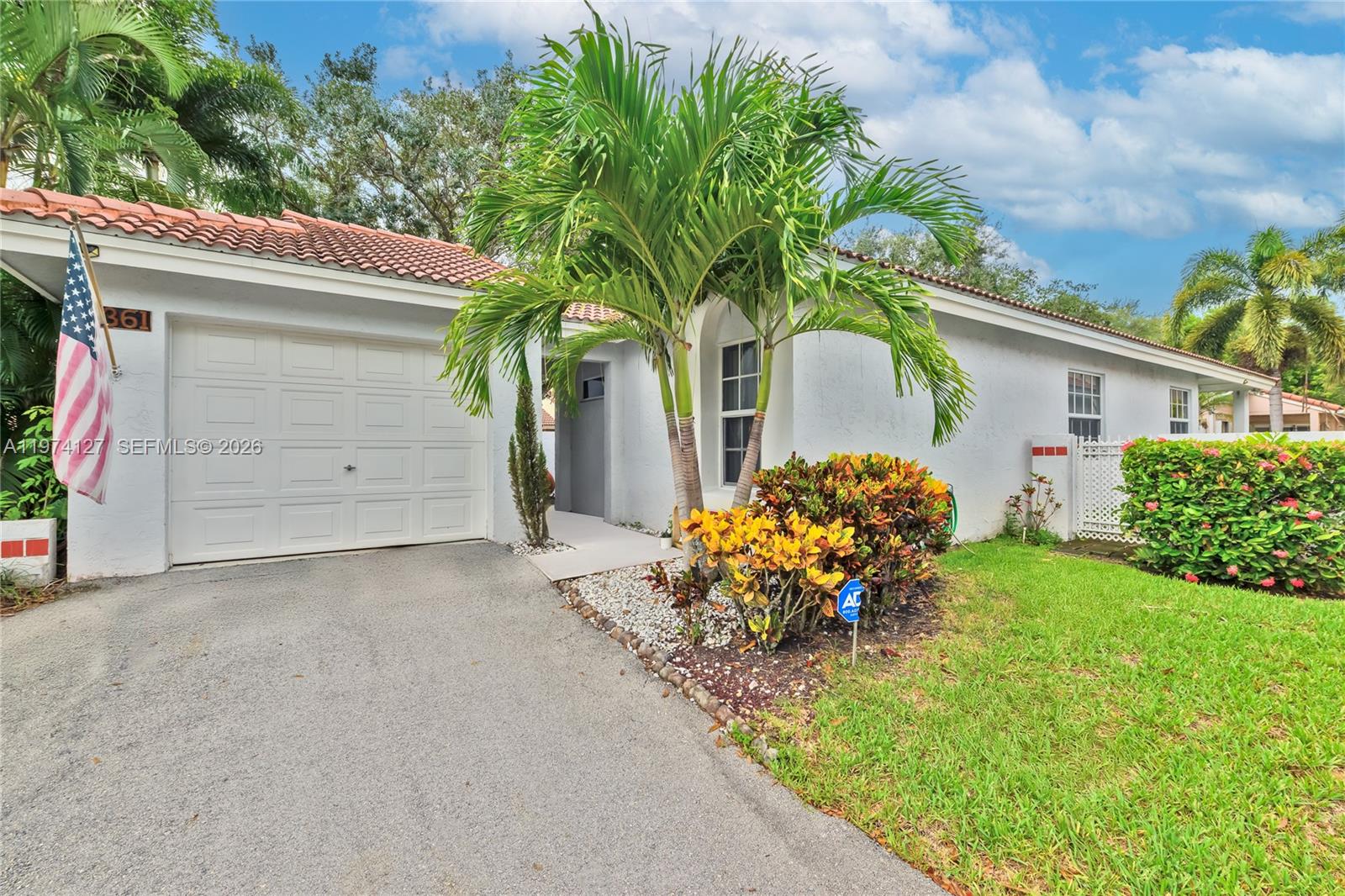 A single-story house with a white stucco exterior, a tile roof, and a palm tree — 1361 Seagrape Cir, Weston FL 33326, WESTON, FL
