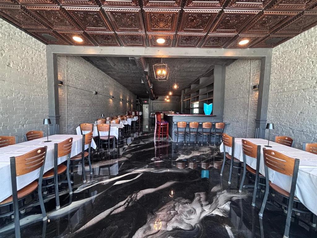 A restaurant interior features a black and white marbled floor, brick walls, and a coffered ceiling — 240 S BEACH STREET, DAYTONA BEACH, FL