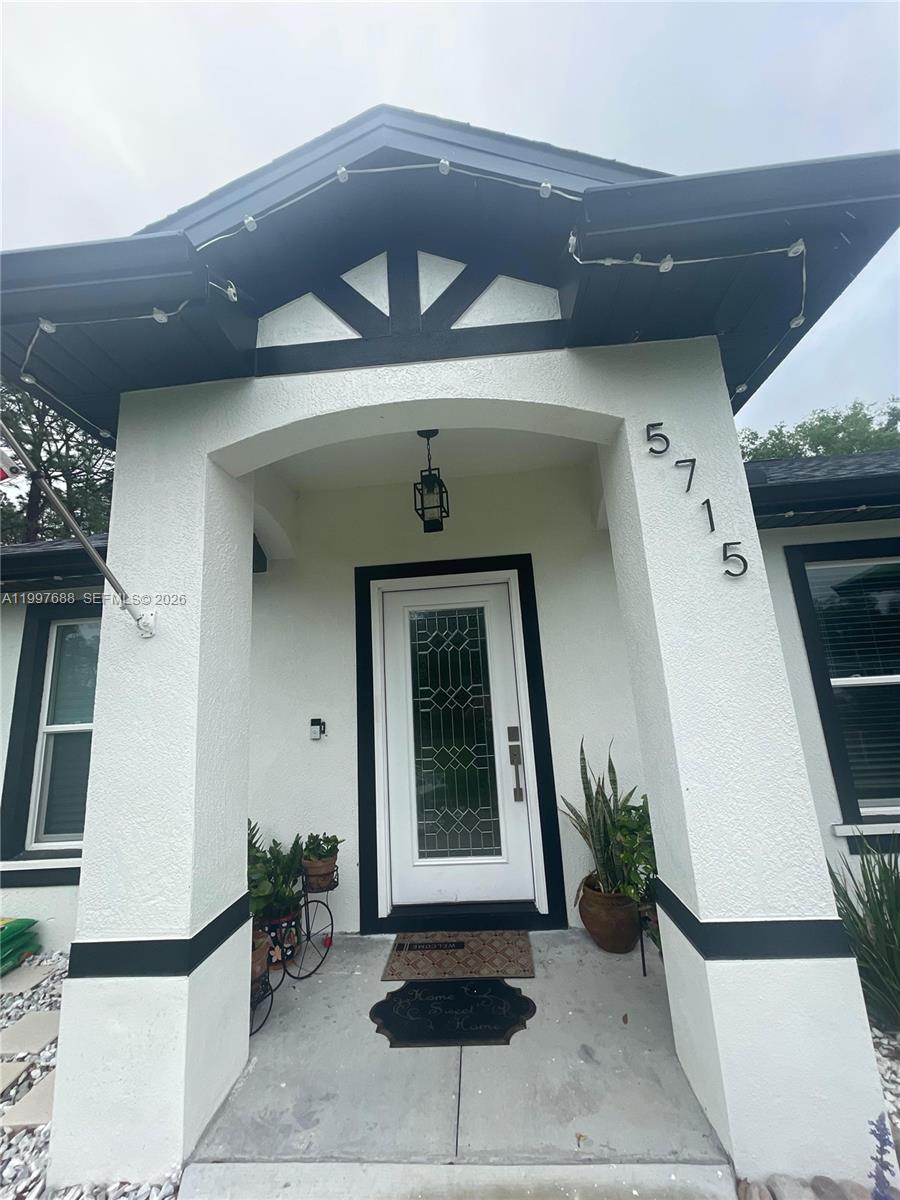 The front entrance of a house features a white door with glass panels and columns — 5715 SW 128TH Pl, Ocala FL 34473, OCALA, FL