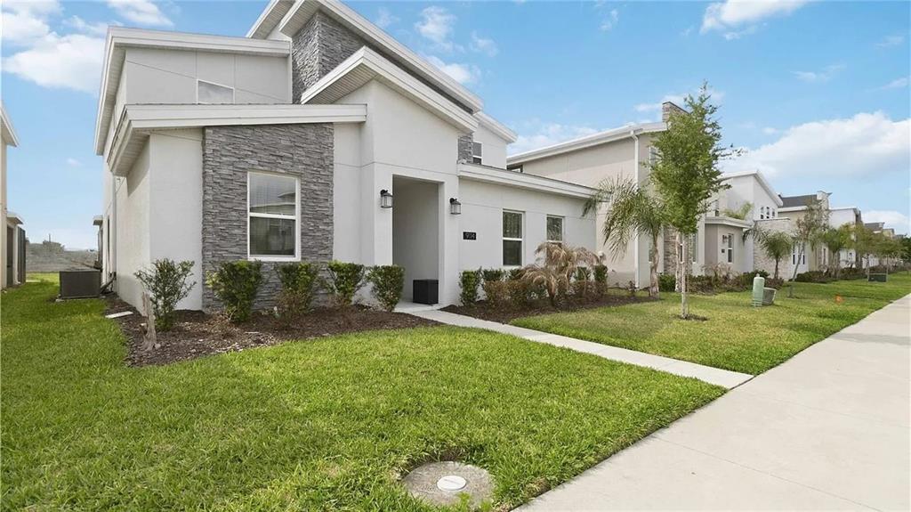 A modern two-story house with white stucco, stone accents, and a front walkway — 9114 SOMMERSET HILLS DRIVE, DAVENPORT, FL