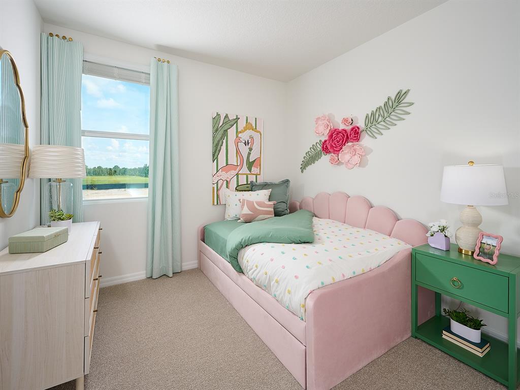 A bedroom features a pink scalloped bed, a green nightstand, and flamingo wall art — 13403 SHELLMORE AVENUE, PALMETTO, FL