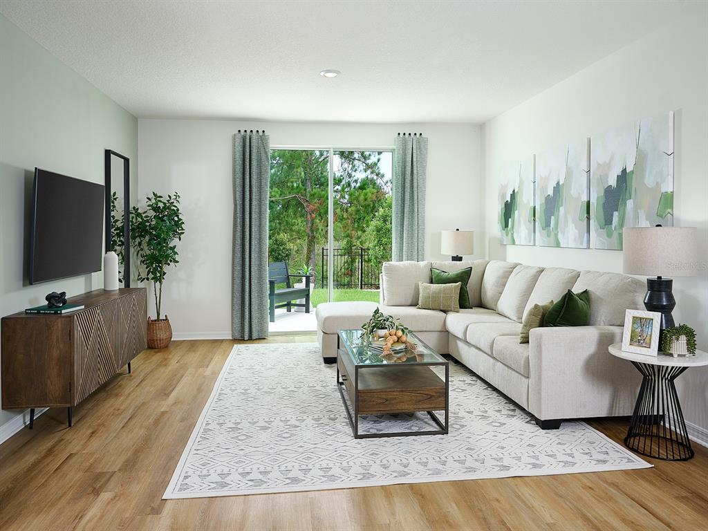 A living room features a sectional sofa, a patterned rug, and a sliding glass door — 13403 SHELLMORE AVENUE, PALMETTO, FL