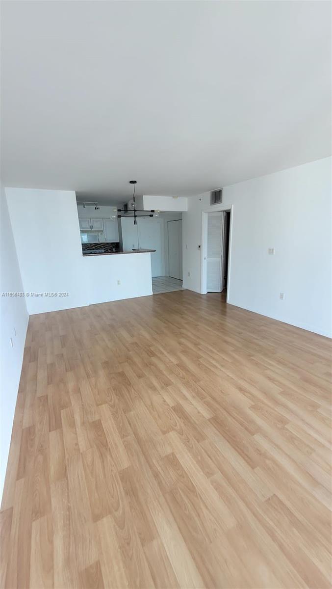 An open-concept living area features light wood-look flooring and a kitchen with a breakfast bar — 1155 Brickell Bay Dr # 2805, Miami FL 33131, MIAMI, FL