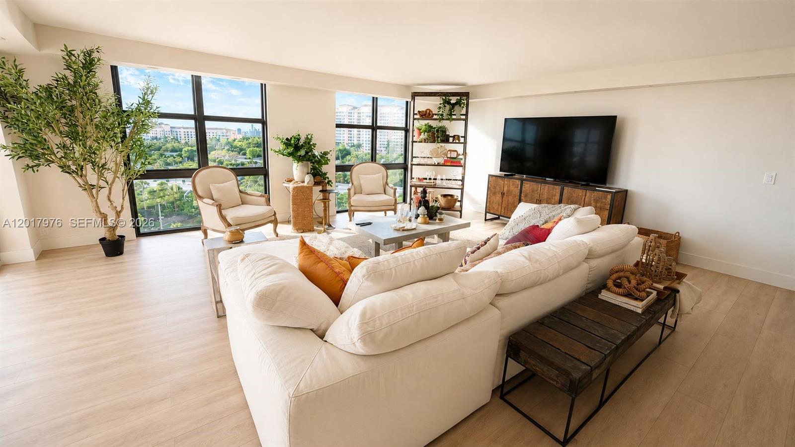 A bright living room features a large white sectional sofa, two armchairs, and floor-to-ceiling windows — 1121 Crandon Blvd # E708, Key Biscayne FL 33149, KEY BISCAYNE, FL
