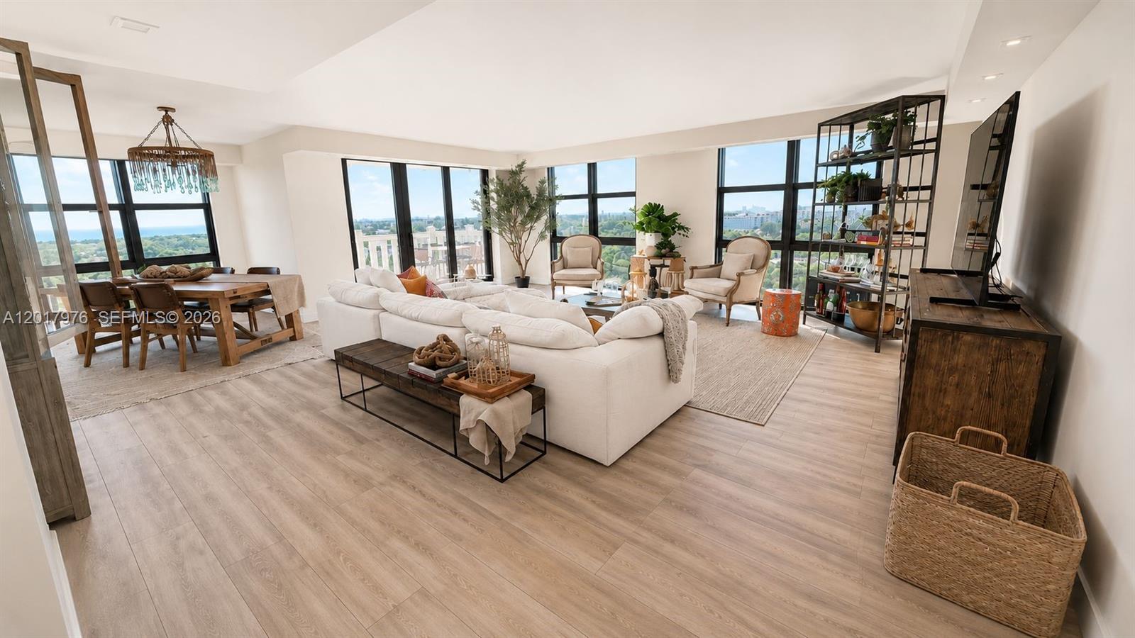 A bright, open-concept living and dining area features light wood flooring and floor-to-ceiling windows — 1121 Crandon Blvd # E708, Key Biscayne FL 33149, KEY BISCAYNE, FL