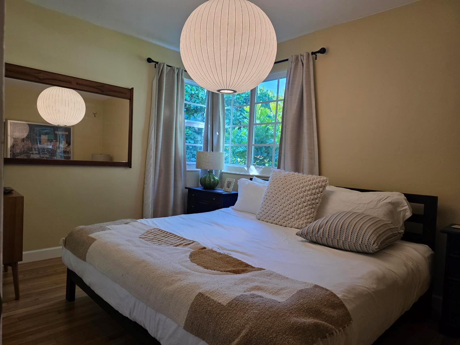 A bedroom with a bed, a large paper pendant light, and a mirror on the wall — 1118 N K Street, FL 33460, FL