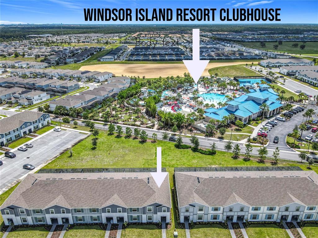 An aerial view shows a resort clubhouse with a pool and adjacent residential townhomes — 967 PARADISE DRIVE, DAVENPORT, FL