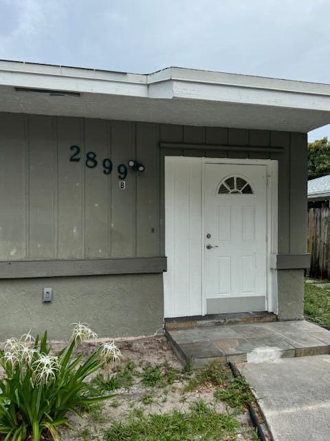 The exterior of a gray building features a white door and the house number 2899 — 2899 NE 2nd Avenue, Boca Raton FL 33431, BOCA RATON, FL