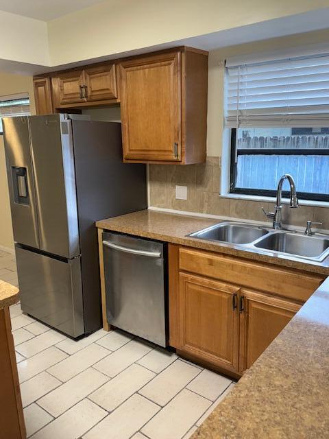 A kitchen features stainless steel appliances, wood cabinets, a double sink, and tiled flooring — 2899 NE 2nd Avenue, Boca Raton FL 33431, BOCA RATON, FL