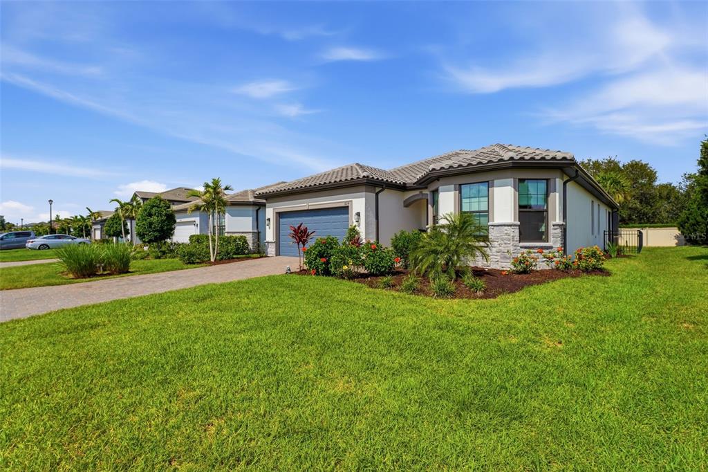 A single-story suburban house with a blue garage door and stone facade exterior — 824 GADWALL COURT, BRADENTON, FL