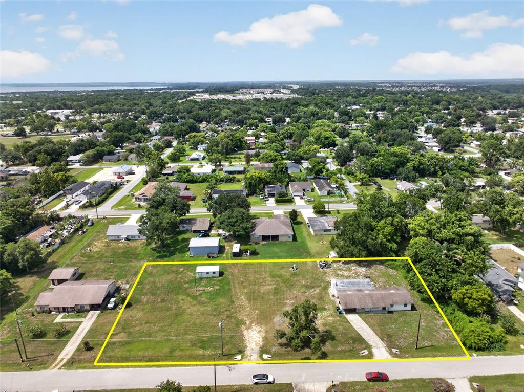 An aerial view shows a large, grassy residential lot with a house and shed — 212 15TH AVENUE, OCOEE, FL
