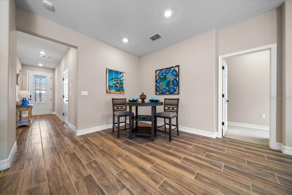 A dining area features a small round table, two chairs, and wood-look tile flooring — 5360 NW 34TH STREET, OCALA, FL