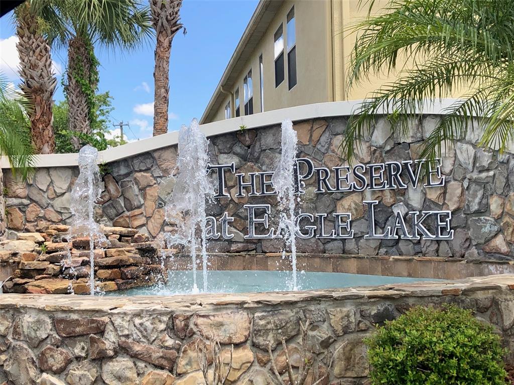 A stone monument sign with a fountain reads The Preserve at Eagle Lake — 599 LAKE EAGLE LANE, SANFORD, FL