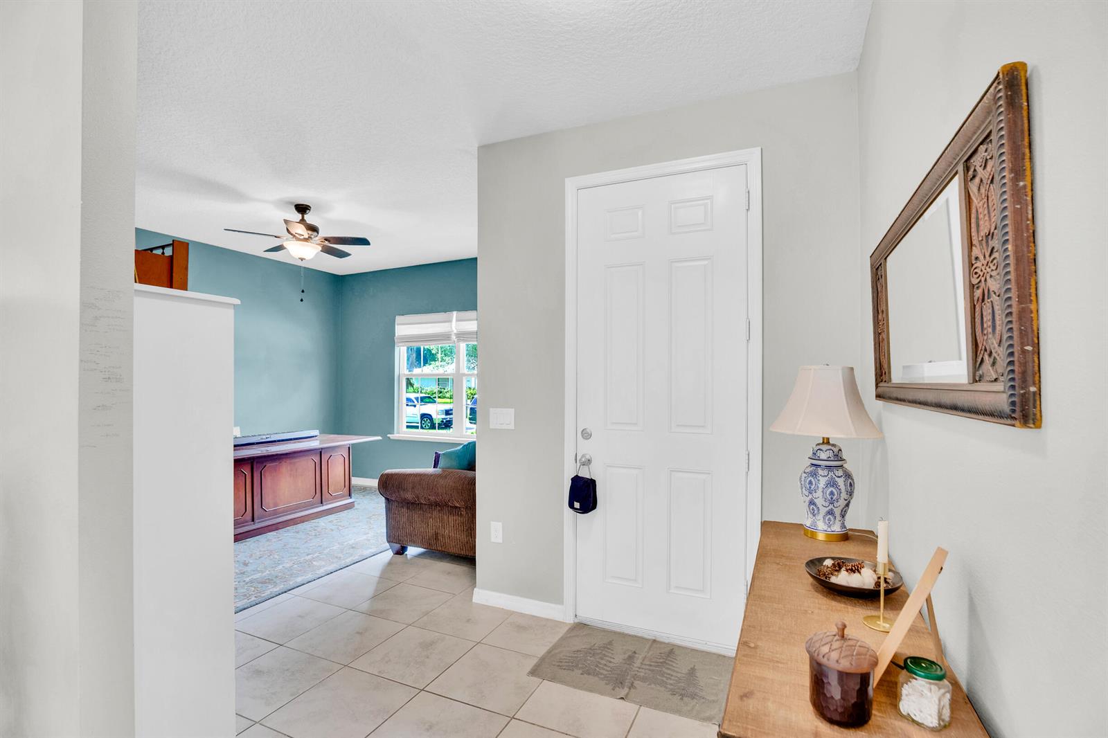 An entryway with tile flooring leads into a blue-walled room with a desk and window — 956 Claire Avenue, Sebastian FL 32958, SEBASTIAN, FL