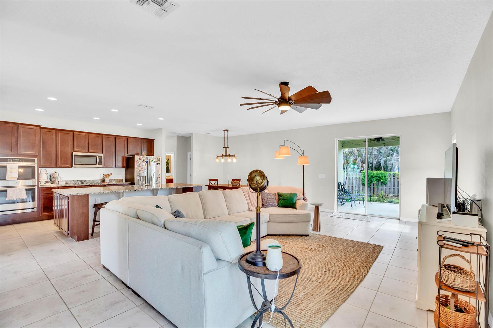 An open-concept living room and kitchen featuring a large sectional sofa and tile flooring — 956 Claire Avenue, Sebastian FL 32958, SEBASTIAN, FL