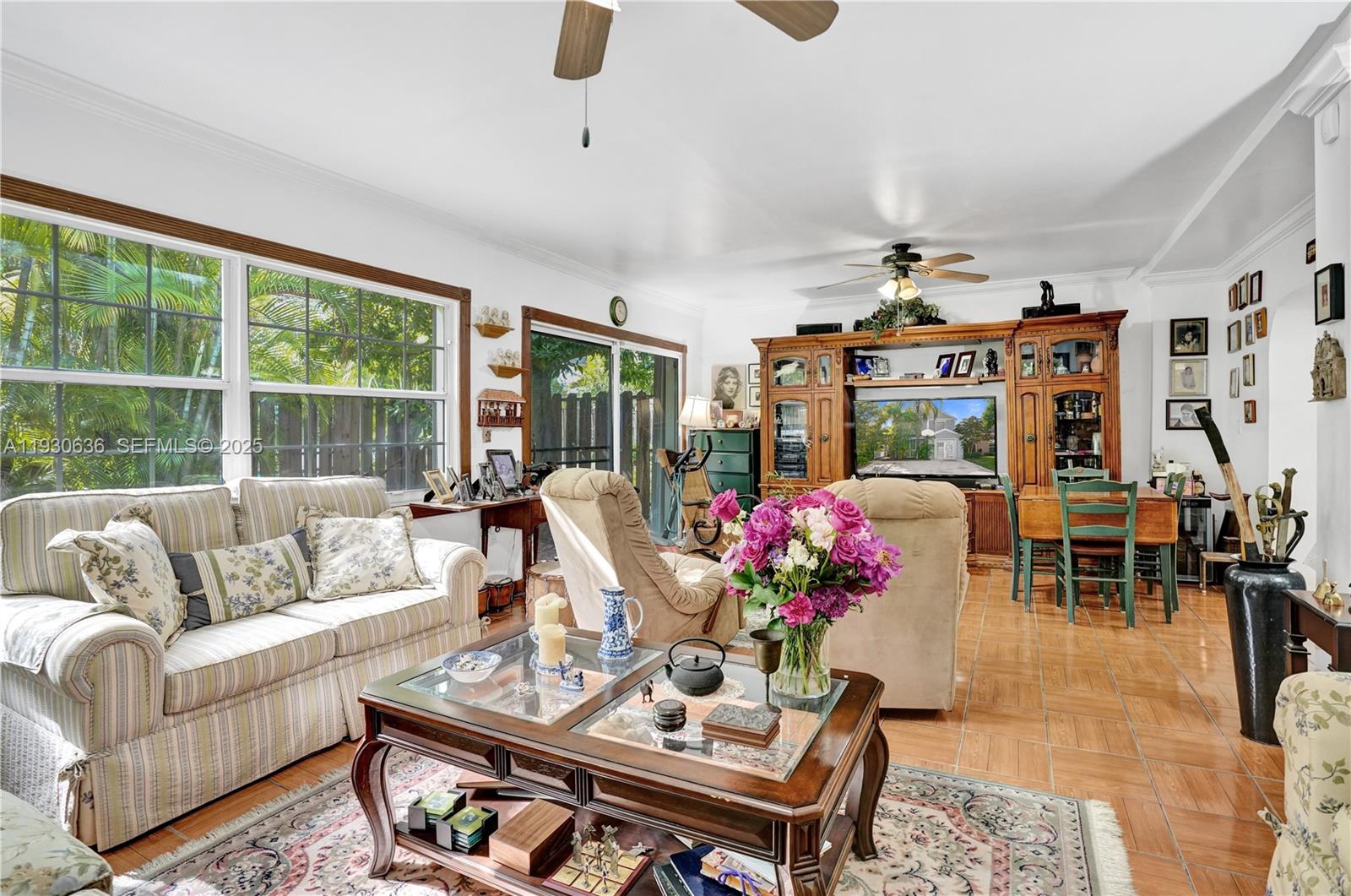 A living room features tile floors, a wooden entertainment center, and a floral-patterned sofa — 11728 SW 118th Ter, Miami FL 33186, MIAMI, FL