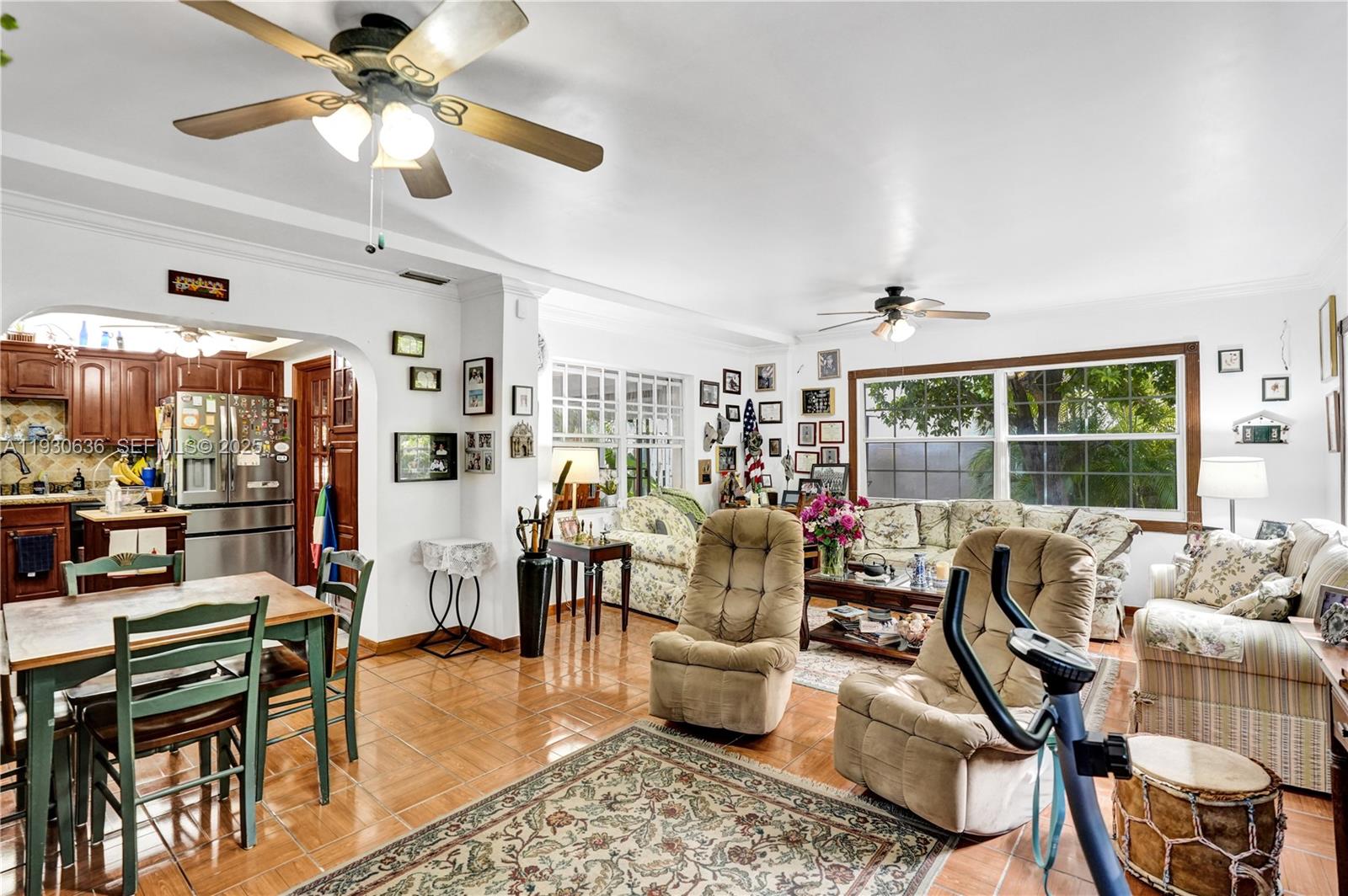 A living room and dining area with tile floors, ceiling fans, and floral-patterned furniture — 11728 SW 118th Ter, Miami FL 33186, MIAMI, FL